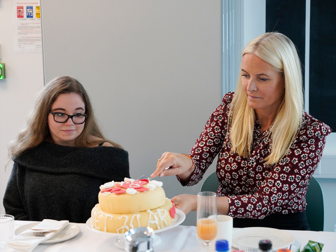 Kronprinsessen tar hull på kaken sammen med Isabelle B. Buene. Foto: Terje Bendiksby / NTB